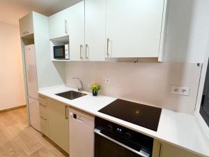 a kitchen with white cabinets and a sink at Hauzify I Can Xasil in Blanes