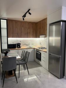 uma cozinha com uma mesa e um frigorífico de aço inoxidável em Soft Loft ЖК Київський em Ternopil