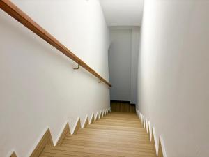 a staircase in a building with white walls and wooden floors at Hauzify I Can Xasil in Blanes