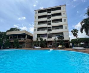 a building with a swimming pool in front of a building at Hihotel Saraburi in Ban Rong Saeng