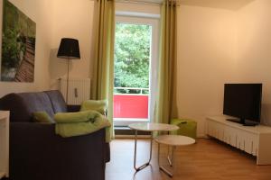 a living room with a couch and a television at Travel Apartments in Münster