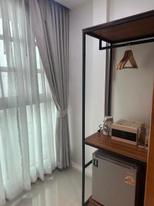 a room with a window with white curtains at Madugu Service Apartment in Chiang Mai +109 photos