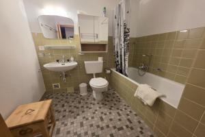 a bathroom with a toilet and a sink and a tub at Bruyères B22 in Verbier
