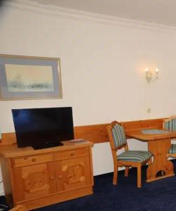 Una televisión o centro de entretenimiento en Apartment im Wellnesshotel an der Piste, Sauna, Pool, Frühstück All-Inclusive möglich