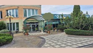 a building with a courtyard with plants in front of it at Quartet-Quality Restauracja i Noclegi in Pniewy
