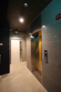 a hallway with a elevator and a door in a building at Nabi Hostel in Seoul