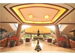 a lobby with stairs and a statue in the middle at Queen Margarette Hotel in Camp Wilhelm