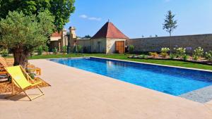a swimming pool in front of a house with a yard at La Chartreuse de Dauzac in Labarde