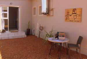 sala de estar con mesa, sillas y puerta en Ley-Lia Guest House en Aranos