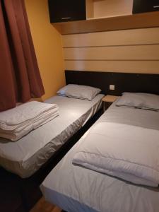 En eller flere senge i et værelse på Mobil home 6 personnes avec Lave Linge et TV