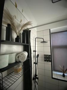 ein Badezimmer mit einem Regal mit Handtüchern und einem Spiegel in der Unterkunft Apartment Modern & Cozy - City Center Saldus in Saldus