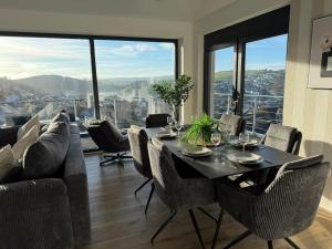 Un comedor con mesa y sillas y una gran ventana. en Moderne 3-Zimmer-Wohnung mit Panoramablick, en Bad Berleburg 10 fotos más