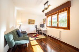 a living room with a couch and a desk at Casa Costera Gijón By Silastur in Gijón