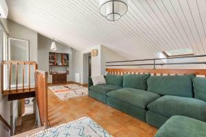 een woonkamer met een groene bank in een huis bij Beautiful air-conditioned house and heated pool in La Celle-sous-Gouzon +34 foto's