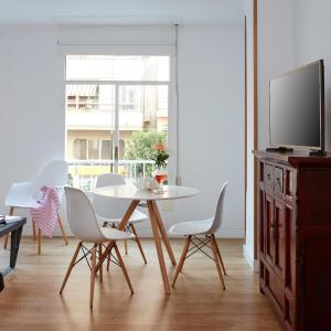 a dining room with a table and chairs and a tv at Lodgingmalaga Cristo de la Epidemia in Málaga