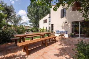 een houten picknicktafel op een bakstenen terras bij Beautiful air-conditioned house and heated pool in La Celle-sous-Gouzon
