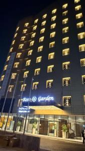 ein Gebäude mit einem Schild an der Vorderseite in der Unterkunft Rose Garden Hotel فندق روز جاردن in Riad