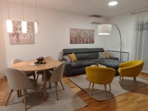 un salon avec un canapé, une table et des chaises dans l'établissement Apartment Ali, à Zagreb