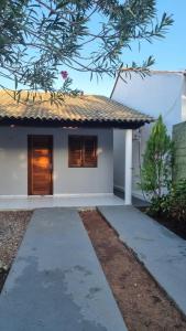 a small white house with a pathway in front of it at Casa 03 in Parnaíba