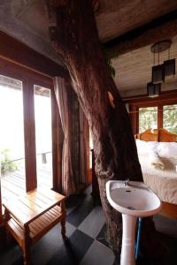 a bathroom with a tree and a sink next to a bedroom at P&P Coffee & Resort Maesariang in Ban Kat