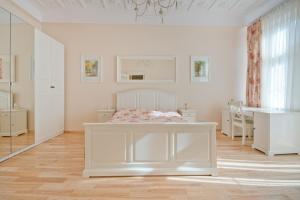 biała sypialnia z łóżkiem i biurkiem w obiekcie Imperial Apartments - Classic w mieście Sopot