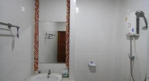 a white bathroom with a shower and a sink at Phakawan Hotel in Ban Nong Chik