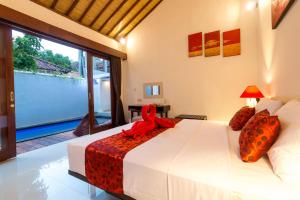 Un dormitorio con una cama con una cinta roja. en Little Coco Gili Trawangan Villas, en Gili Trawangan