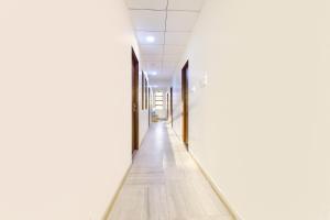 un pasillo vacío de un edificio de oficinas con paredes blancas y suelo de madera en FabHotel Connect, en Jaipur