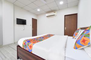 Un dormitorio con una cama y un televisor en la pared. en FabHotel Connect, en Jaipur