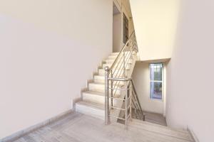 Una escalera de caracol en una habitación blanca con una ventana. en FabHotel Connect, en Jaipur