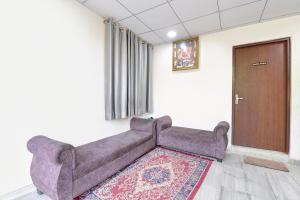 Un sofá en una habitación con una puerta y una alfombra. en FabHotel Connect, en Jaipur