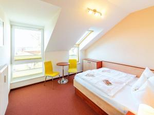 1 Schlafzimmer mit einem Bett, 2 Stühlen und einem Tisch in der Unterkunft Ferienwohnung mit Boddenblick - D 132.073 in Rerik