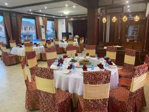a large banquet hall with tables and chairs with food on them at Anoulack Khen Lao Hotel in Muang Phônsavan