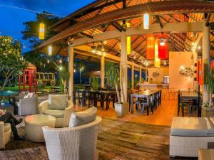 Lucerne Villa Resort في Ban Rai Khlong Sai: جناح مع كراسي وطاولات ومطعم