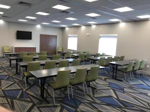 a conference room with tables and chairs and a screen at Holiday Inn Express and Suites Hannibal-Medical Center By IHG in Hannibal