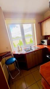 een keuken met een spoelbak en een raam bij Makowa 2 Street in Konin