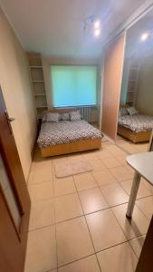 een kamer met 2 bedden op een tegelvloer bij Makowa 2 Street in Konin