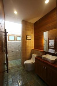 a bathroom with a toilet and a sink at Chiangkham Luang Resort in Ban Huai Sai