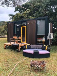 a large couch sitting in front of a tiny house at Dreamseed Cabin by Tiny Away in Yandina