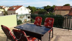 a balcony with a table and chairs on a balcony at Apartmani Agard in Brodarica