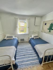 due letti in una piccola stanza con una finestra di PINE TREE COTTAGE LIMIT 5 cottage a East Sebago Altre 7 foto
