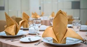 a table with plates and wine glasses and napkins at Lotus Hotel Subang in Subang