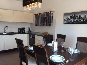 a kitchen and dining room with a table and chairs at Apartmani Agard in Brodarica