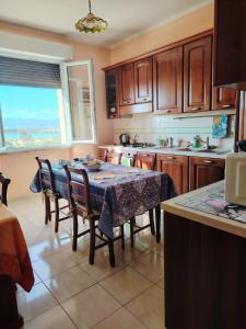 a kitchen with a table and some chairs and a window at La Playa di Ponente in Cagliari