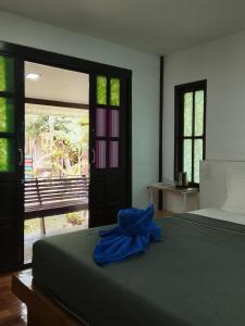 a bedroom with a bed with a blue towel on it at DD Beach Houses in Phra Ae beach