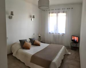 ein weißes Schlafzimmer mit einem großen Bett mit zwei Kissen in der Unterkunft Gîtes Villa Beau Soleil Agde in Agde