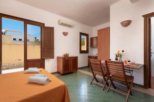 a room with a bed and a table and chairs at Case vacanza Al Paradise in San Vito lo Capo