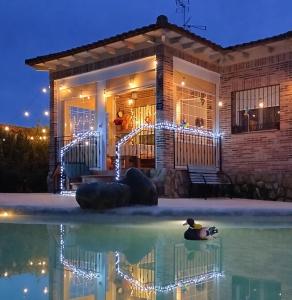 Casa Rural Dani Escalona في طليطلة: منزل به حمام سباحة في الليل