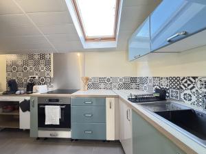 a kitchen with a sink and a stove top oven at Maison Cosy & Colorée à Valence-en-Poitou Jardin & Parking in Couhé-Verac