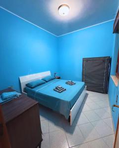 a blue bedroom with a bed and a table at GC Petit Palais Lampedusa in Lampedusa